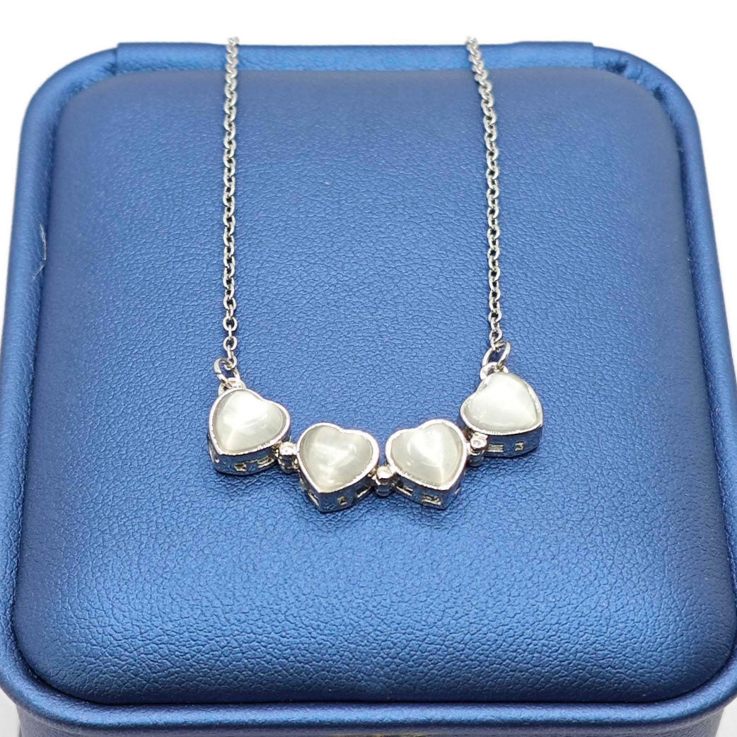 “Étreinte” Clover Pendant Necklace — Platinum‑Tone Chain, White Cat’s‑Eye Inlay
